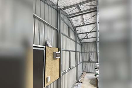 Inside a steel shed, a small plywood board fixed to the wall