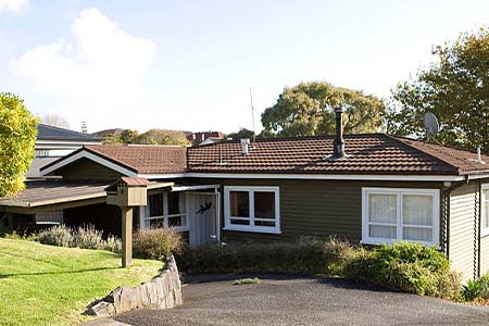 A single-storey brick and weatherboard house with a tile roof and a driveway